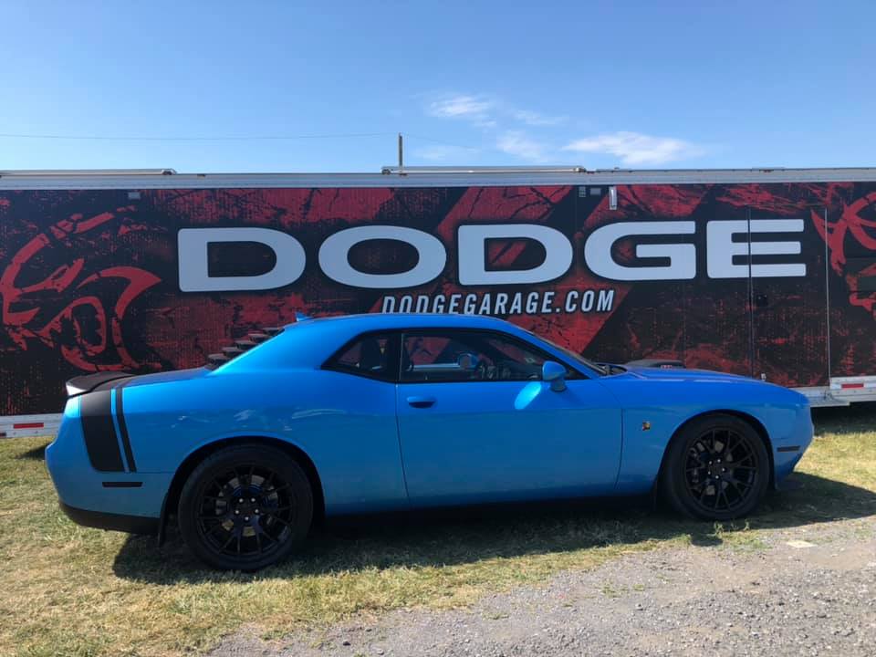 Side view of the B5 Blue Challenger in front of a Dodge display